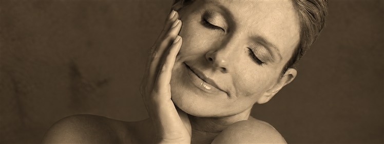 Woman with closed eyes resting her hand against her face